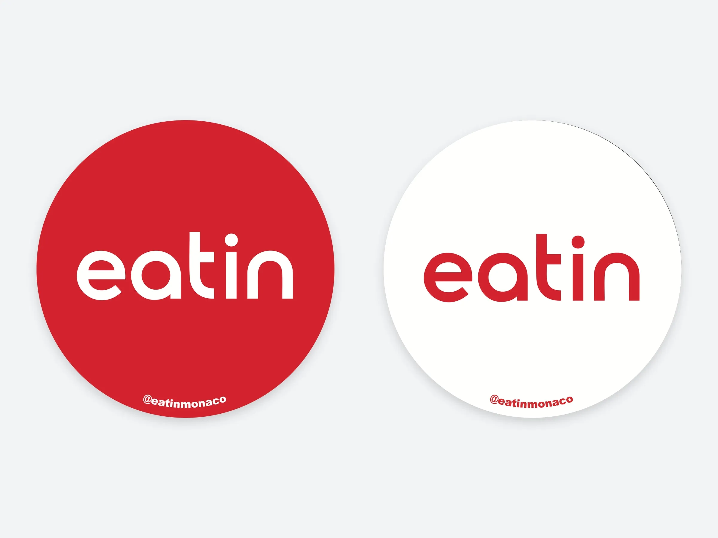 Print files for two round stickers, one red with the eatin wordmark in white and one white with the wordmark in red, each with @eatinmonaco along the bottom edge
