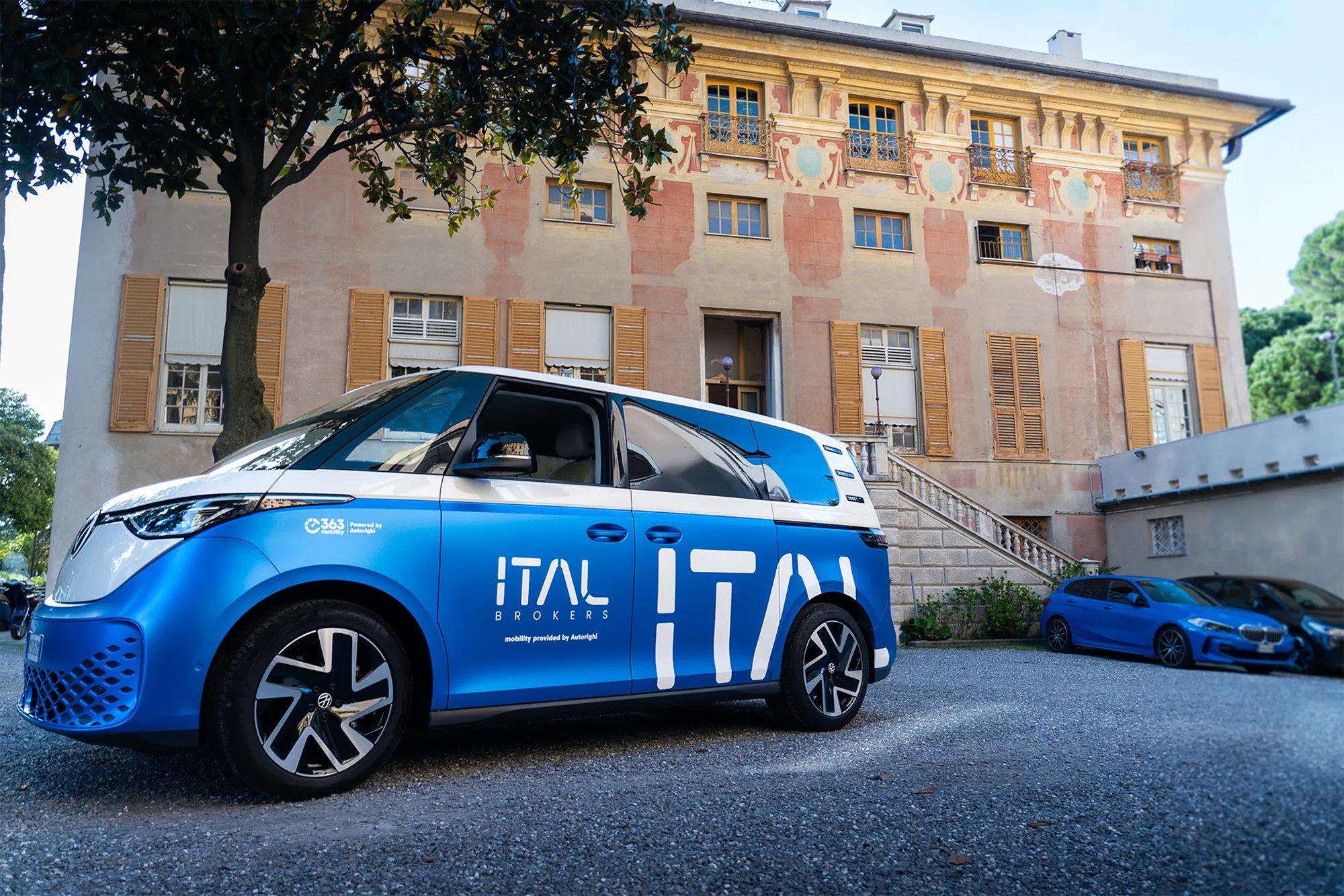 The ITAL-branded Volkswagen ID. Buzz parked in front of a frescoed palazzo in Genoa