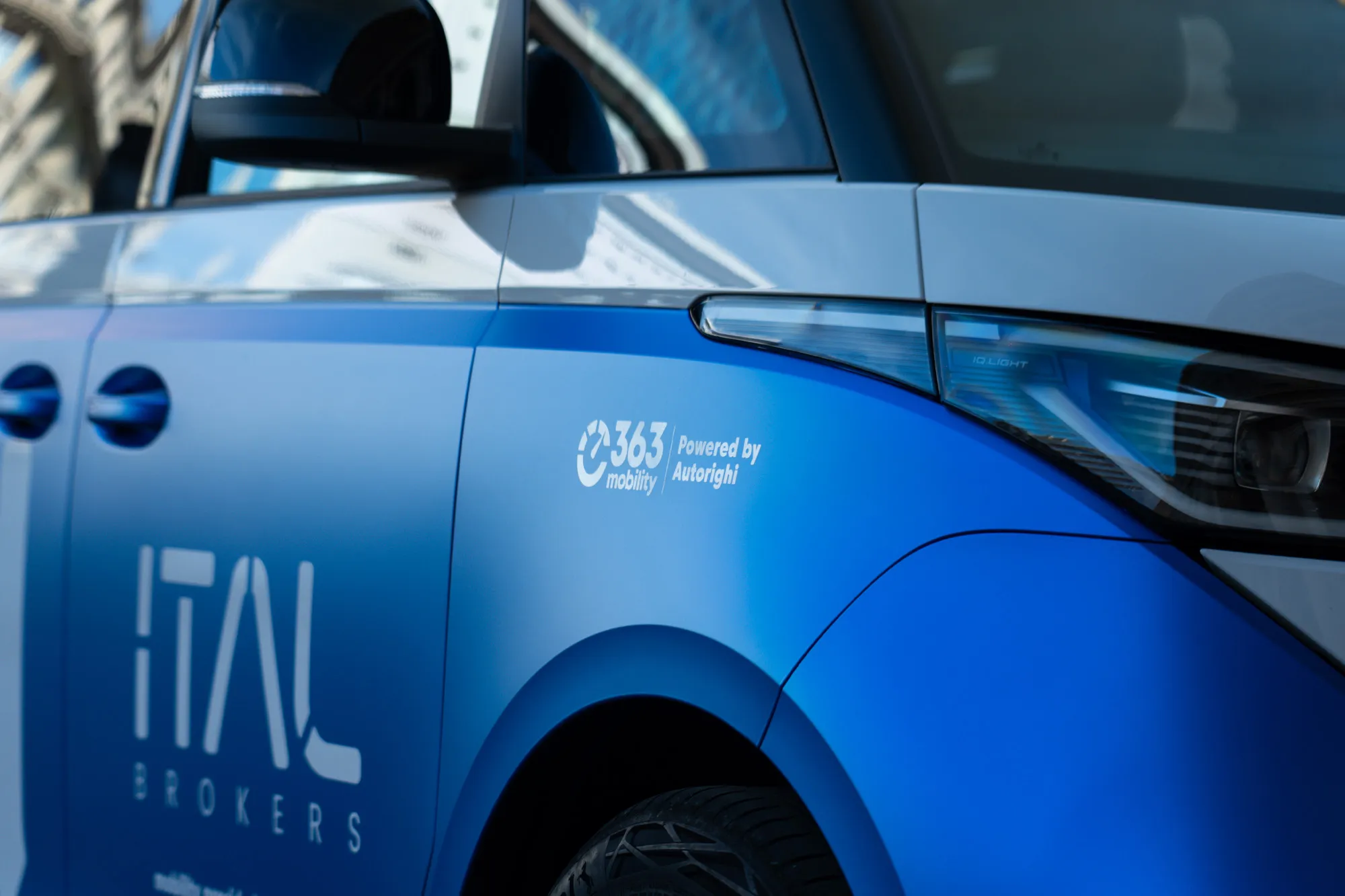Close-up of the ID. Buzz's blue side panel with the ITAL Brokers lettering and a partner decal by the headlight